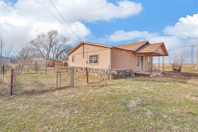 view of side of home with a yard and fence