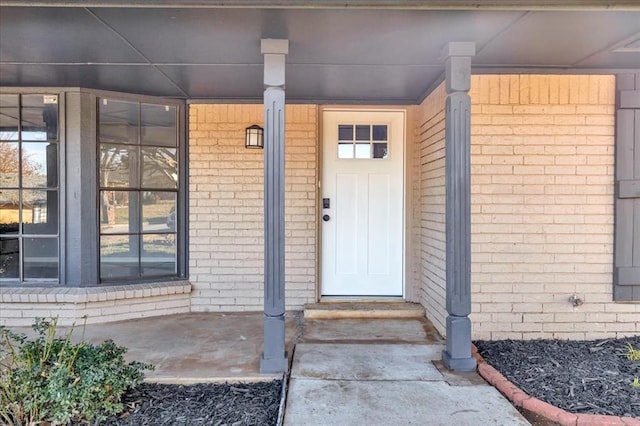 entrance to property featuring brick siding