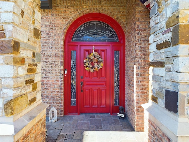 doorway to property featuring brick siding