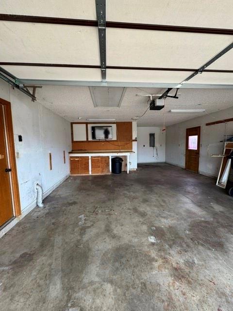 garage featuring electric panel and a garage door opener