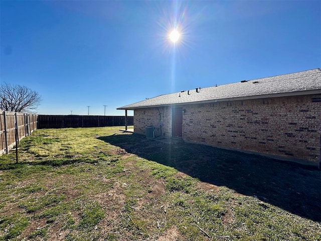 view of yard featuring a fenced backyard and central AC