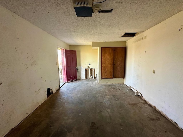 empty room with a textured ceiling and concrete floors