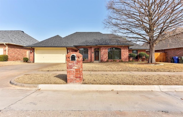 view of front of property featuring a shingled roof, brick siding, driveway, and an attached garage