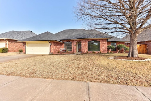 view of front of house with a garage, a shingled roof, brick siding, concrete driveway, and a front lawn