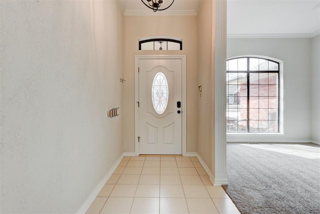 foyer entrance featuring light tile patterned floors, a wealth of natural light, and crown molding