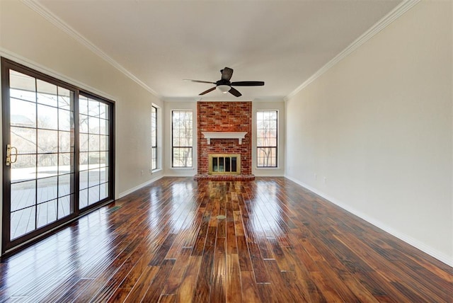 unfurnished living room featuring crown molding, a brick fireplace, dark wood finished floors, and baseboards