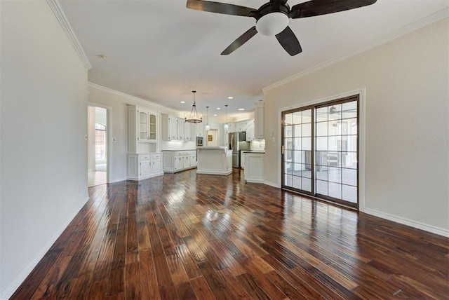 unfurnished living room featuring baseboards, ornamental molding, dark wood-type flooring, ceiling fan with notable chandelier, and recessed lighting