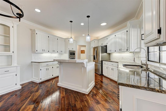 kitchen featuring crown molding, white cabinetry, stainless steel appliances, and a sink