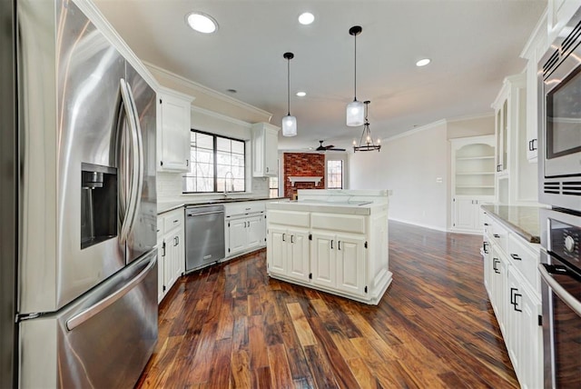 kitchen featuring stainless steel appliances, dark wood-type flooring, crown molding, and a kitchen island