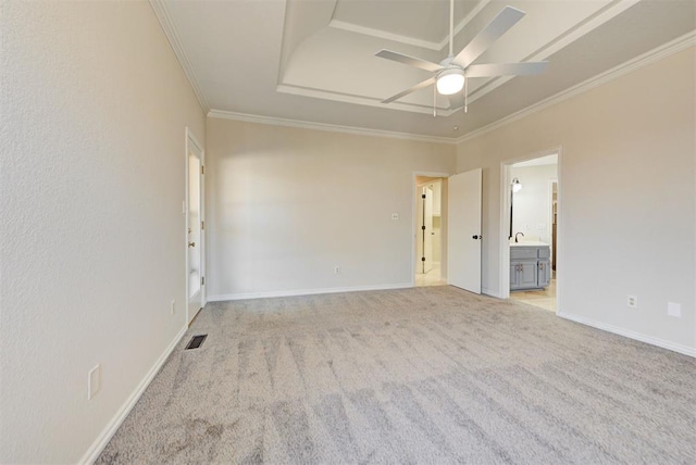 empty room with light colored carpet, a sink, visible vents, and crown molding