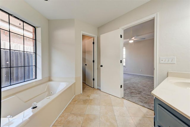 full bathroom with a jetted tub, tile patterned floors, vanity, and a healthy amount of sunlight