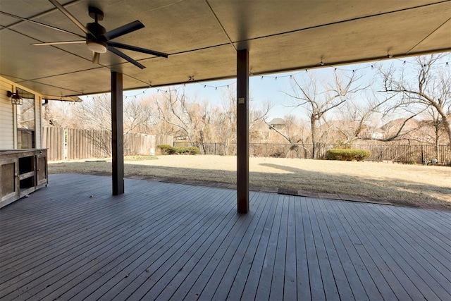 wooden terrace with a fenced backyard and a ceiling fan