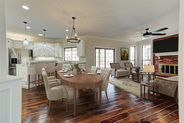 3705 Barwick Dr, Norman, OK 73072 - dining space with dark wood finished floors, crown molding, a ceiling fan, recessed lighting, and a fireplace