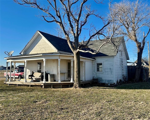 view of front of house featuring fence, concrete block siding, a porch, and a front yard