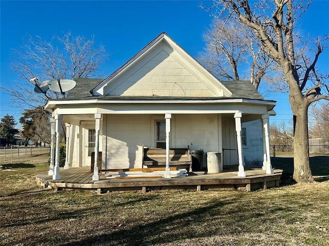 back of property with fence and a lawn