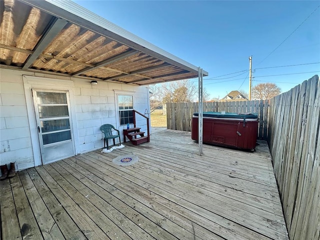 wooden deck with a hot tub and fence