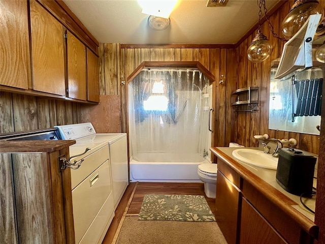 bathroom with shower / bath combination with curtain, wood walls, washing machine and clothes dryer, and toilet