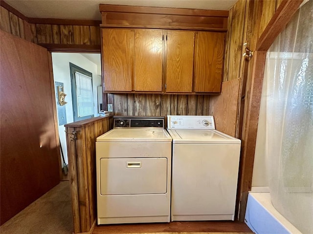 laundry area featuring wood walls and washing machine and clothes dryer