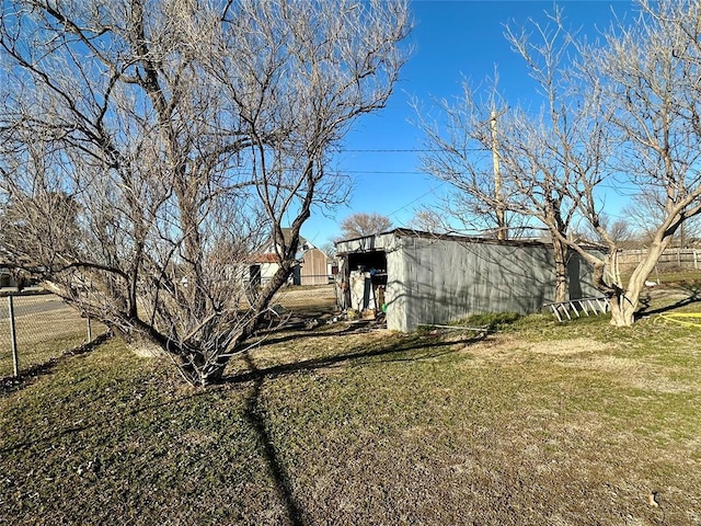 exterior space with a pole building, a lawn, an outdoor structure, and fence