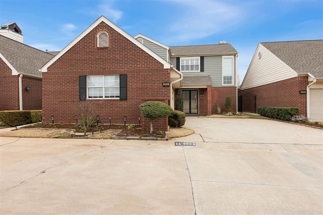 traditional home with concrete driveway and brick siding