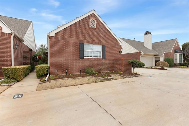 view of front facade featuring driveway and brick siding