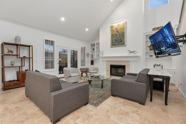 living area featuring high vaulted ceiling, a tile fireplace, a wealth of natural light, and built in features