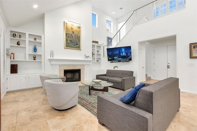 living room featuring stairs, built in shelves, a high ceiling, and a fireplace