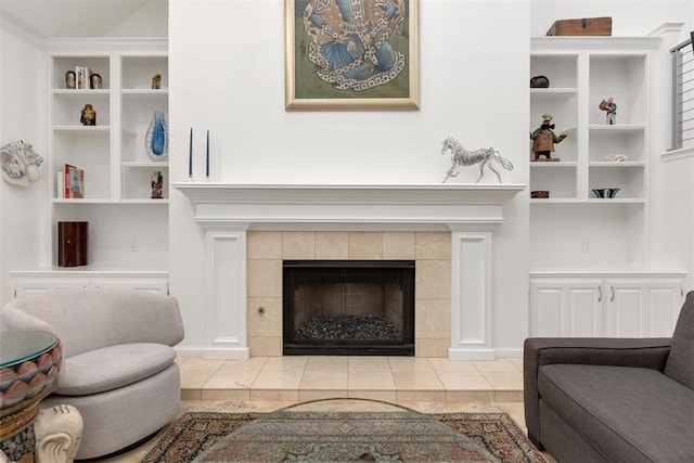 living room with a tile fireplace and built in features