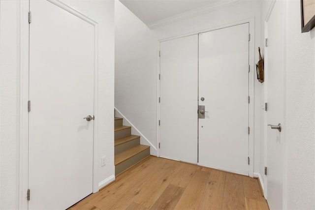 entrance foyer featuring light wood finished floors and crown molding