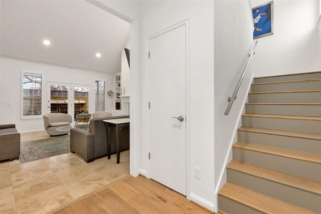 stairway with baseboards, wood finished floors, and recessed lighting