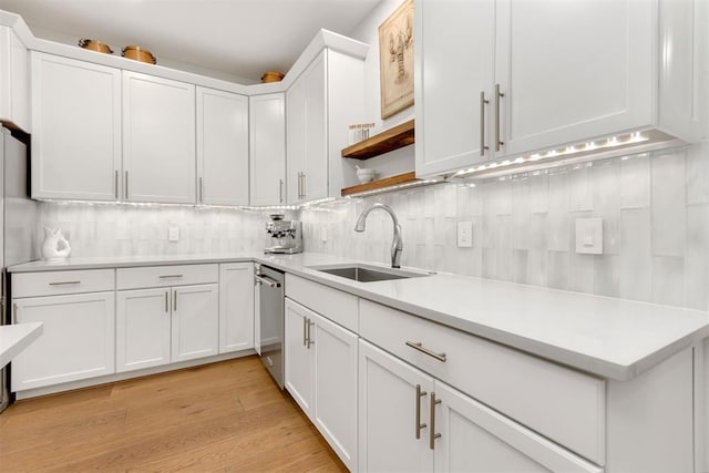 kitchen featuring light countertops, a sink, and white cabinetry