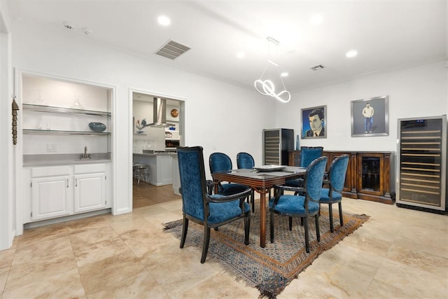 dining space featuring beverage cooler, ornamental molding, visible vents, and recessed lighting