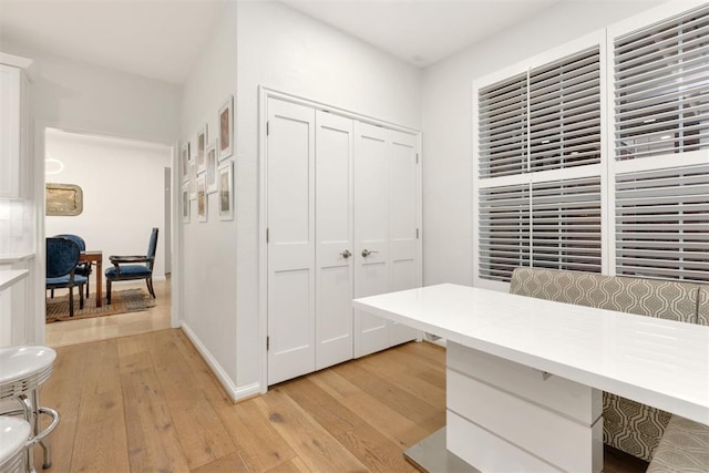 office area with light wood-style floors and baseboards