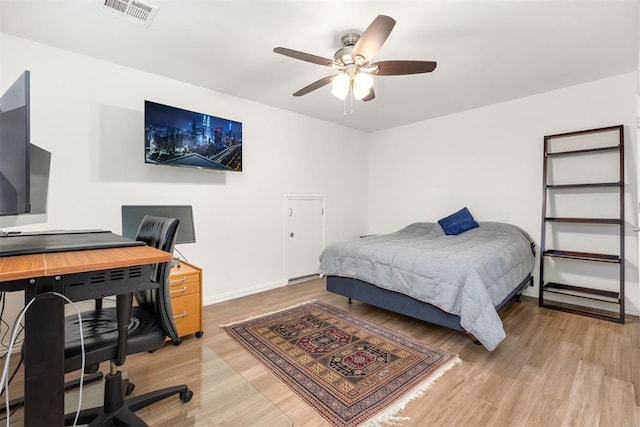 bedroom featuring visible vents, ceiling fan, light wood-style flooring, and baseboards