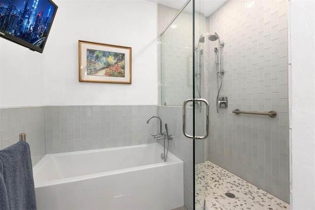 bathroom featuring a garden tub and a shower stall