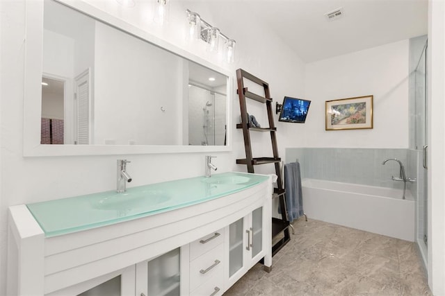 full bath featuring double vanity, visible vents, a sink, and a bath