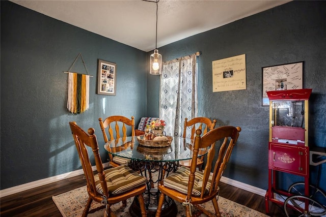 dining area with baseboards and wood finished floors