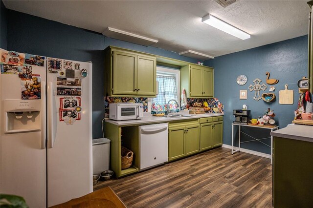 kitchen featuring white appliances, green cabinetry, dark wood-style flooring, light countertops, and a sink