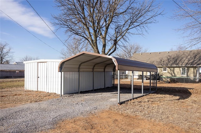 view of vehicle parking featuring a carport, gravel driveway, and fence