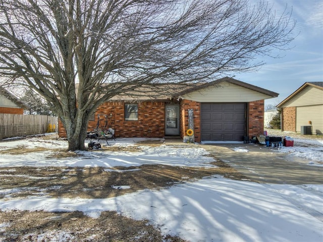 single story home featuring driveway, an attached garage, fence, cooling unit, and brick siding