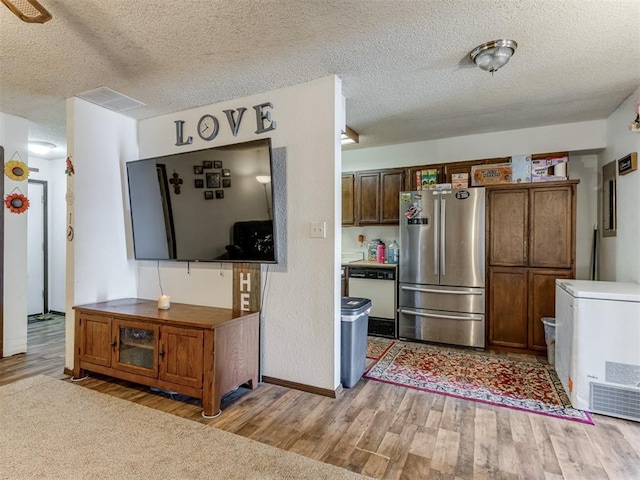 kitchen featuring light wood-type flooring, freestanding refrigerator, dishwasher, and fridge