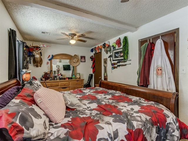 bedroom with a ceiling fan, beam ceiling, visible vents, and a textured ceiling