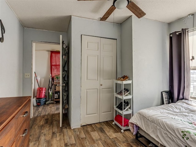 bedroom with a closet, a textured ceiling, ceiling fan, and dark wood-type flooring