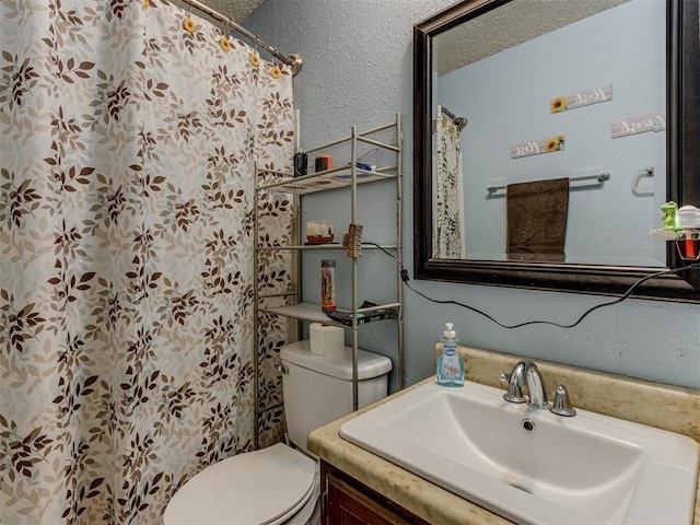 bathroom with toilet, a textured wall, a textured ceiling, and vanity