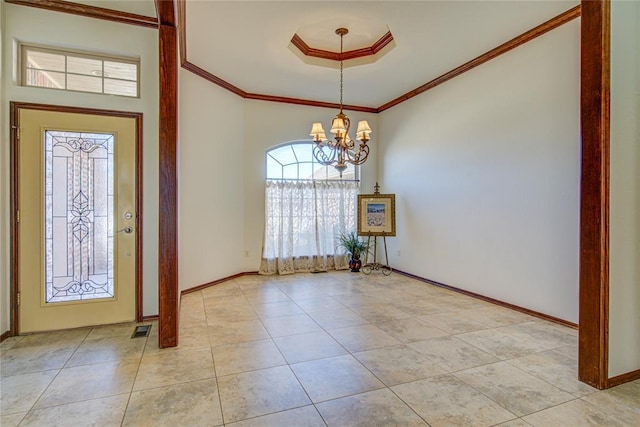 entrance foyer featuring a chandelier, visible vents, baseboards, a tray ceiling, and crown molding