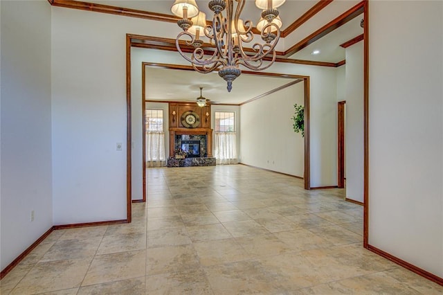 unfurnished living room featuring ornamental molding, ceiling fan with notable chandelier, baseboards, and a premium fireplace