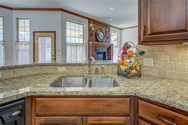 kitchen with decorative backsplash, ornamental molding, a healthy amount of sunlight, a sink, and dishwasher