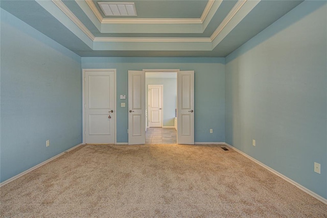 unfurnished bedroom with visible vents, baseboards, ornamental molding, carpet, and a tray ceiling