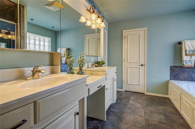 bathroom featuring two vanities, a garden tub, and a sink