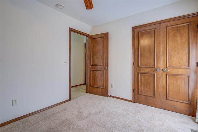 unfurnished bedroom with carpet, a ceiling fan, and baseboards